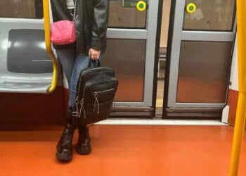 Mujer con mochila en el suelo dentro de un vagón del Metro de Madrid.