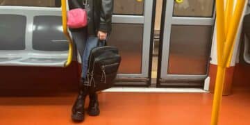 Mujer con mochila en el suelo dentro de un vagón del Metro de Madrid.