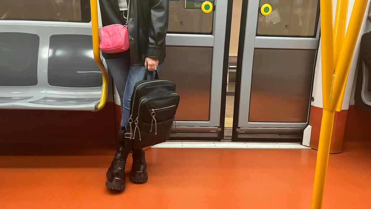 Mujer con mochila en el suelo dentro de un vagón del Metro de Madrid.