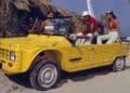 Coche playero amarillo en la playa, icono de la nostalgia veraniega.