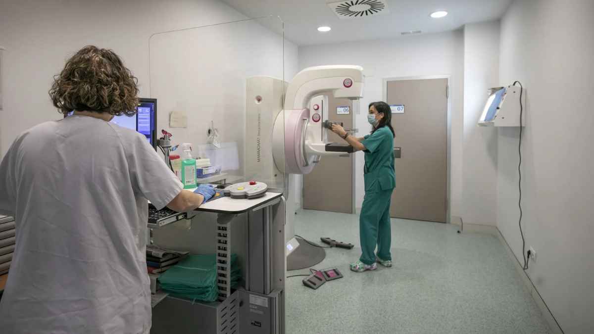 Profesionales sanitarios trabajando con mamógrafo en una consulta médica.