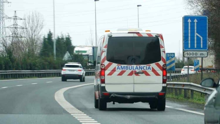 Ambulancia circula por autovía mediante pasillo de emergencia, medida clave del nuevo Reglamento de Circulación 2026 para atascos.