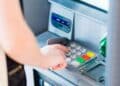 Persona sacando dinero del cajero tras el consejo de la OCU sobre límite máximo seguro en la cuenta bancaria