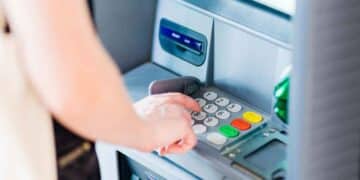 Persona sacando dinero del cajero tras el consejo de la OCU sobre límite máximo seguro en la cuenta bancaria