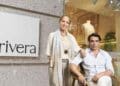 Tienda Rivera de moda sostenible en Madrid con dos personas posando frente al escaparate y logotipo.
