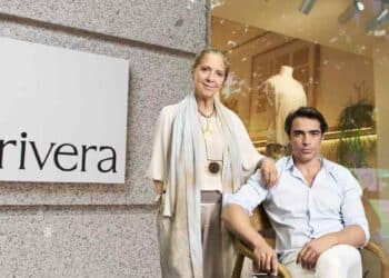 Tienda Rivera de moda sostenible en Madrid con dos personas posando frente al escaparate y logotipo.