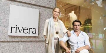 Tienda Rivera de moda sostenible en Madrid con dos personas posando frente al escaparate y logotipo.
