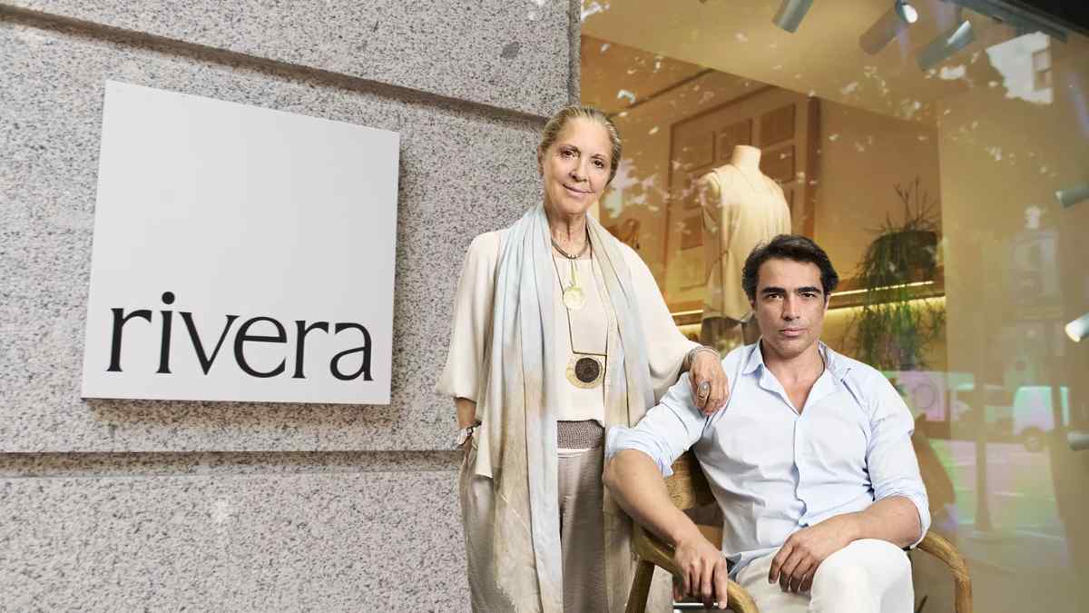 Tienda Rivera de moda sostenible en Madrid con dos personas posando frente al escaparate y logotipo.