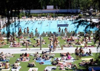 Personas disfrutando de la piscina de Lago en la Casa de Campo de Madrid por 2 euros la entrada.