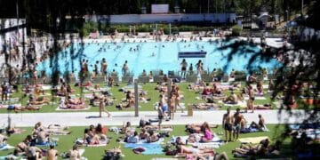Personas disfrutando de la piscina de Lago en la Casa de Campo de Madrid por 2 euros la entrada.