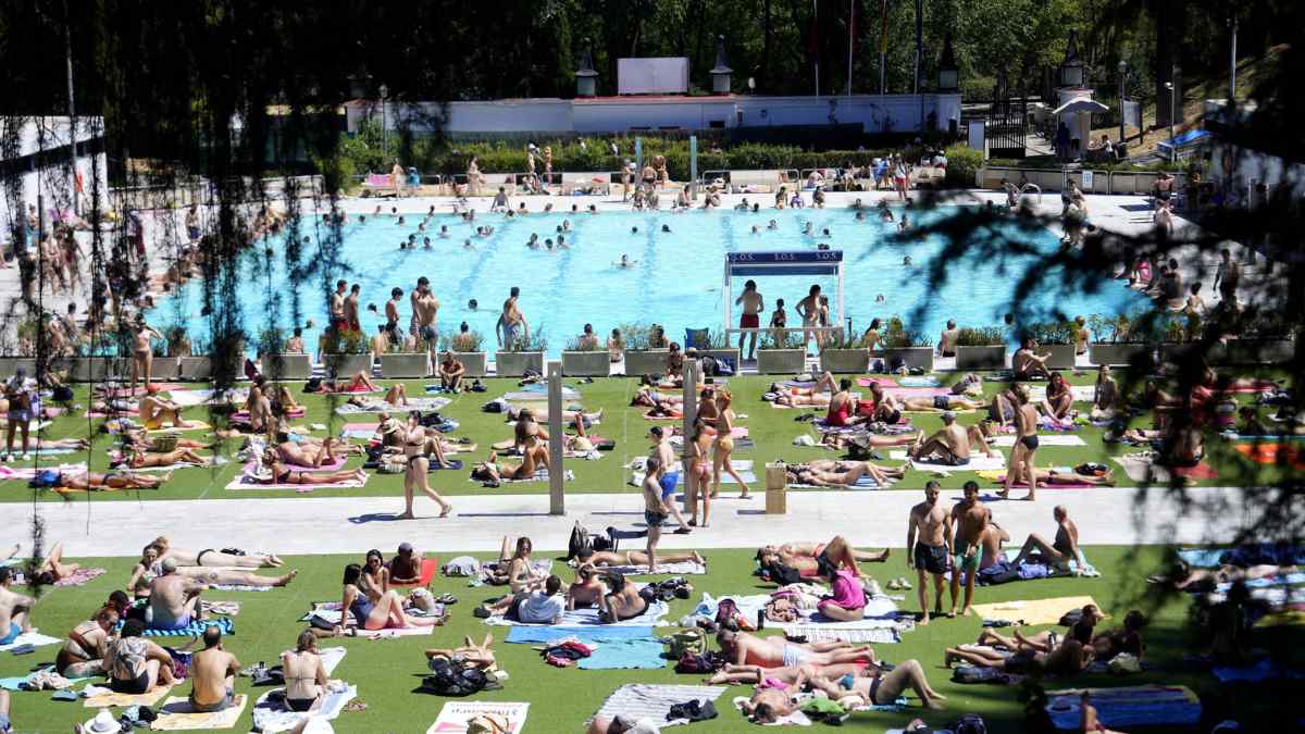 Personas disfrutando de la piscina de Lago en la Casa de Campo de Madrid por 2 euros la entrada.