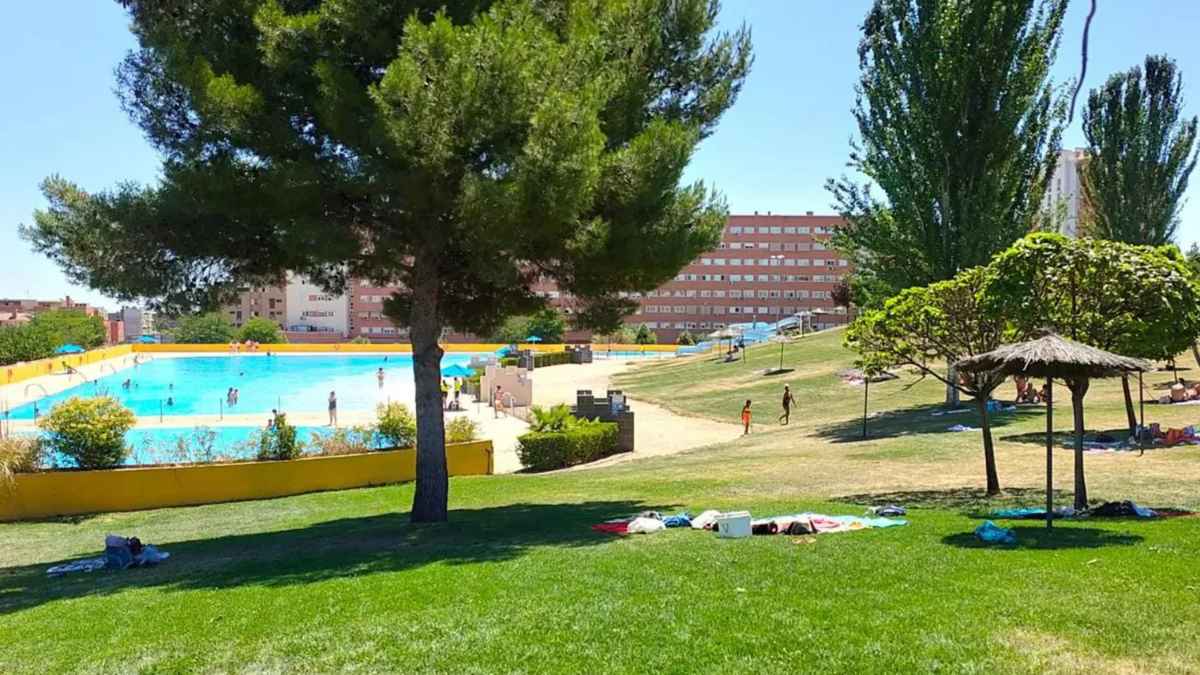Piscina en Madrid con espacio verde ideal para refrescarse durante el verano, disfrutando de un día soleado y caluroso.