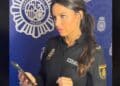 Agente de la Policía Nacional revisa un móvil mientras alerta sobre la estafa telefónica del prefijo exótico.