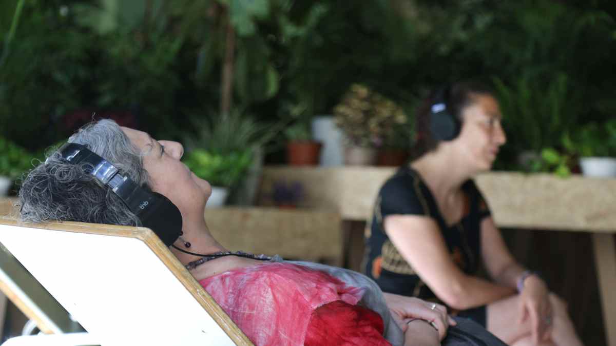 Personas descansando con auriculares en el siestódromo del Refugio Climático del Círculo de Bellas Artes, Madrid.