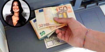 Mano sacando billetes de 50 € de un cajero automático con retrato de una notaria, concepto de riesgos fiscales por herencia.