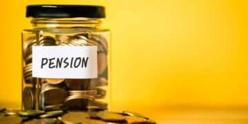 Tarro de cristal con monedas etiquetado como pensión representando el ahorro necesario para la jubilación de jóvenes