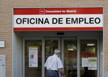 Oficina de Empleo del SEPE en Madrid con hombre mayor solicitando subsidio indefinido para mayores de 52 años.