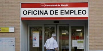 Oficina de Empleo del SEPE en Madrid con hombre mayor solicitando subsidio indefinido para mayores de 52 años.