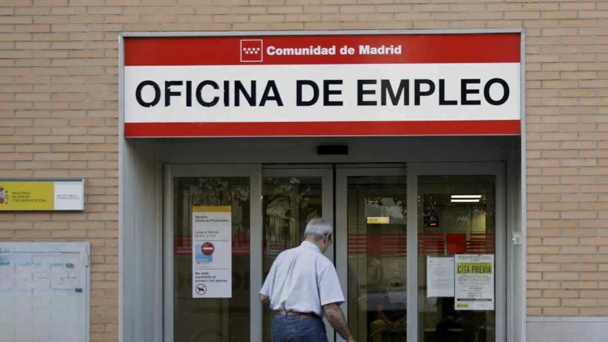 Oficina de Empleo del SEPE en Madrid con hombre mayor solicitando subsidio indefinido para mayores de 52 años.
