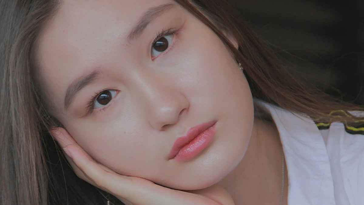 Persona con piel luminosa y saludable, relacionada con el método coreano 'slugging' para una hidratación nocturna.