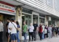 Personas esperando en la oficina de empleo para gestionar subsidios del SEPE.