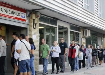 Personas esperando en la oficina de empleo para gestionar subsidios del SEPE.
