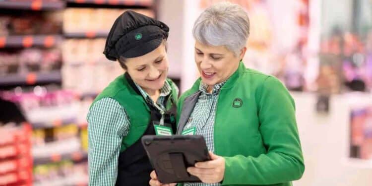 Trabajadoras de Mercadona consultan una tablet en tienda tras sentencia del TSJA sobre despido improcedente y humillaciones.