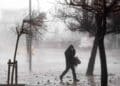 hombre caminando bajo tormenta en madrid con viento fuerte y lluvia.