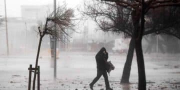 hombre caminando bajo tormenta en madrid con viento fuerte y lluvia.