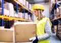 Trabajadora en almacén con caja en ofertas de empleo de la Agencia para el Empleo de Madrid.