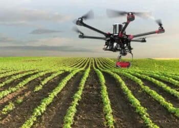 Dron agrícola sobrevolando cultivo en Madrid para vigilar cosechas y permitir el teletrabajo rural.