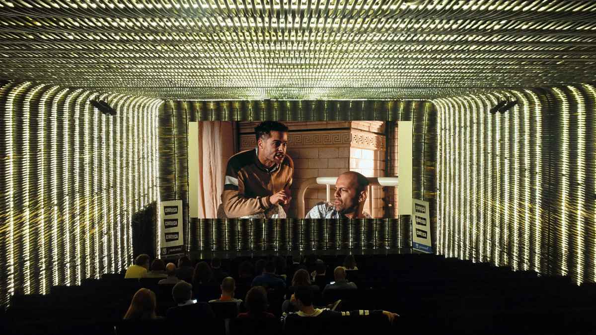 sala de cine en Madrid con público viendo una película en pantalla grande.