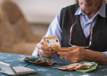 Jubilado contando billetes por devolución del IRPF a mutualistas.