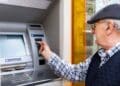 Pensionista retirando dinero en cajero para el cobro de pensión en agosto 2025.