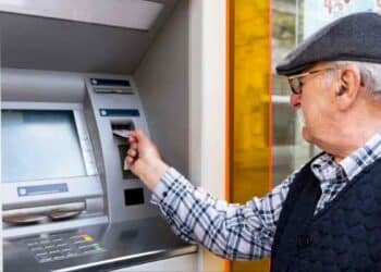 Pensionista retirando dinero en cajero para el cobro de pensión en agosto 2025.