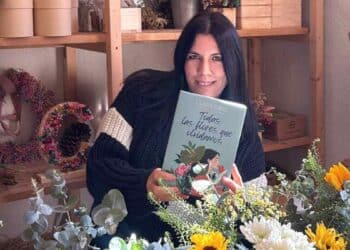 clara sanz con su libro todas las flores que olvidamos en su floristeria rural en somaen soria.
