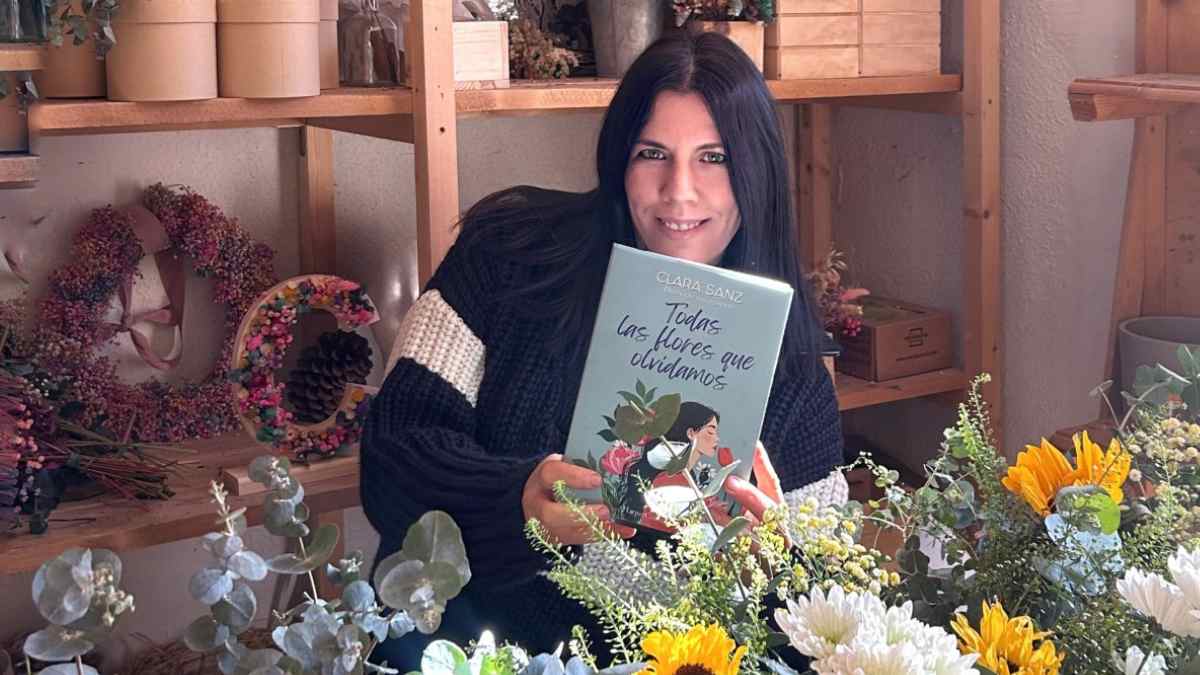 clara sanz con su libro todas las flores que olvidamos en su floristeria rural en somaen soria.