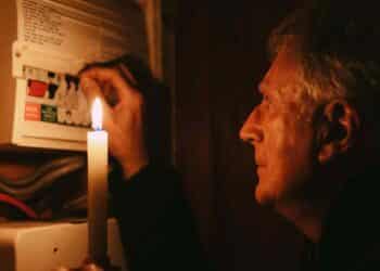 Hombre con vela durante corte de luz en Madrid por mantenimiento eléctrico agosto 2025.