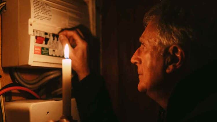 Hombre con vela durante corte de luz en Madrid por mantenimiento eléctrico agosto 2025.