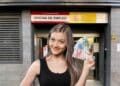 Mujer con dinero frente a oficina de empleo del SEPE en Madrid.