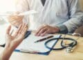 Trabajador en consulta médica durante baja laboral con informe.
