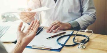 Trabajador en consulta médica durante baja laboral con informe.