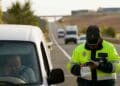 Agente de la Guardia Civil multando a un conductor en carretera.
