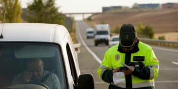 Agente de la Guardia Civil multando a un conductor en carretera.