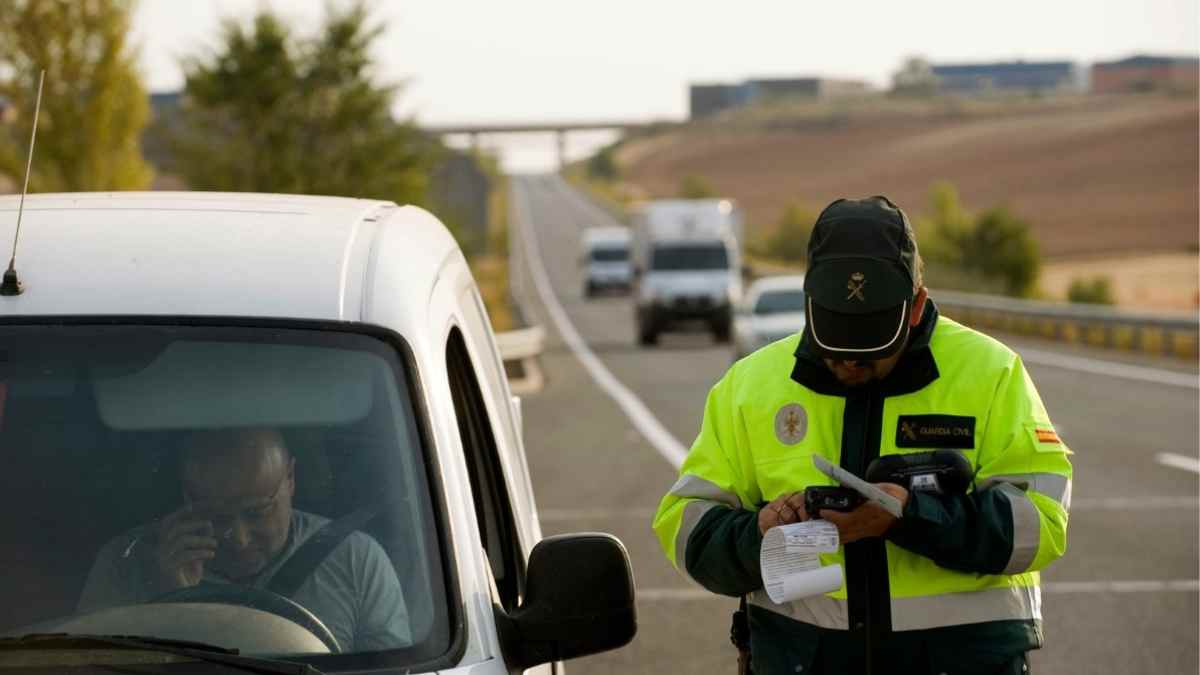 Agente de la Guardia Civil multando a un conductor en carretera.