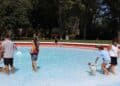 Personas y perros disfrutando del FuenlaDog Fest en la piscina municipal de Fuenlabrada.