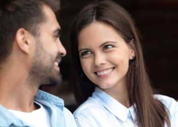 Mujer sonríe mirando a un hombre como gesto que delata atracción según la ciencia.