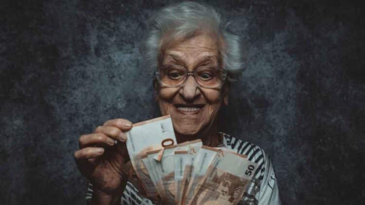 Pensionista recibiendo paga del IMSERSO con complemento del 50% en 2025.