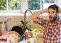Hombre sorprendido por fregadero lleno de platos sucios antes de usar invento de Amazon por menos de 25 euros.