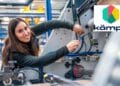 Mujer joven trabajando en máquina industrial dentro del programa de profesión formacional de Kämpe.